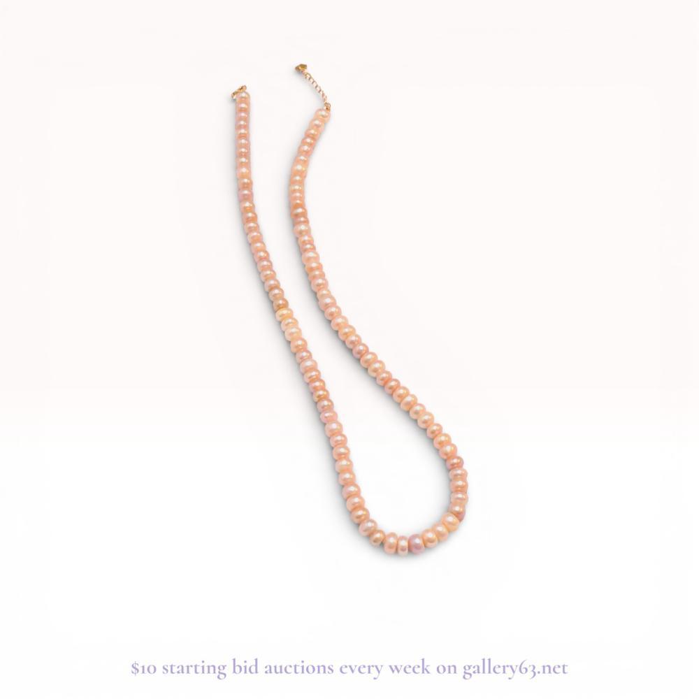 Description
Peach-toned freshwater cultured pearl strand necklace. The single strand features button to semi-round pearls with natural surface characteristics and good luster, secured by a 10 karat yellow gold spring ring clasp. A one-inch extender chain is included, terminating in a heart-shaped tag stamped K10.
Length: 16.5 inches (excluding 1-inch extender).