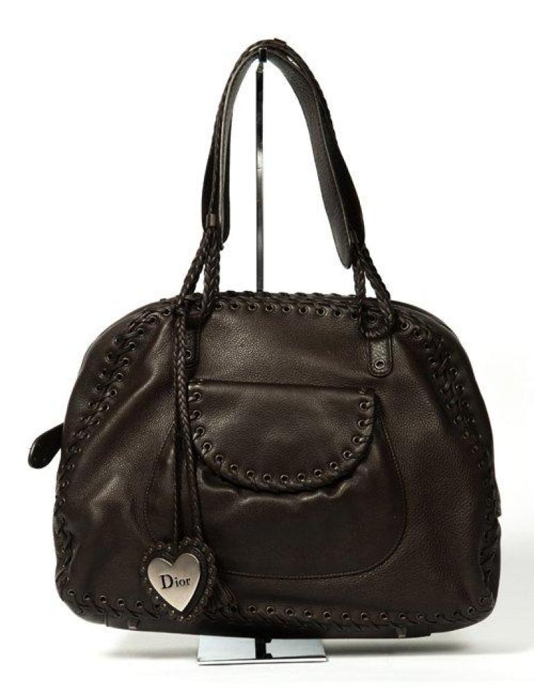 Christian DIOR

Sac 38cm en cuir grené marron, fermeture éclair, coutures rehaussées d’un entrelac de cuir, double poignée, attaches en cuir tréssé, poche extérieure à rabat sur pression. Très bon état (légère tâche).