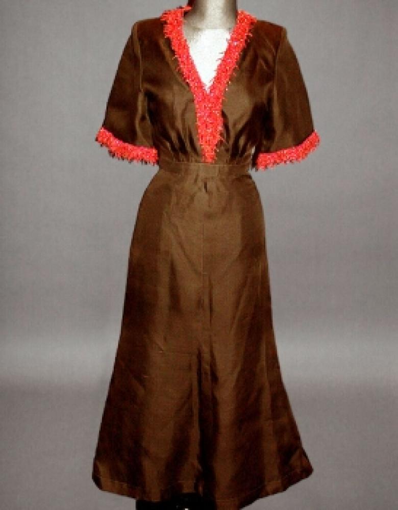 Nina Ricci Coral Trimmed Gown

Lot 562
Nina Ricci Coral Trimmed Gown
 French, 1960s 
 Ankle length, of brown gazar, the bodice with full elbow length sleeves, padded shoulders, V neck, the skirt fitted at the hips and flaring outward from knee level, elaborate coral branch trim around neckline and at sleeve edges, labeled: Nina Ricci/ Paris, size 2. 
Excellent condition, unworn.
