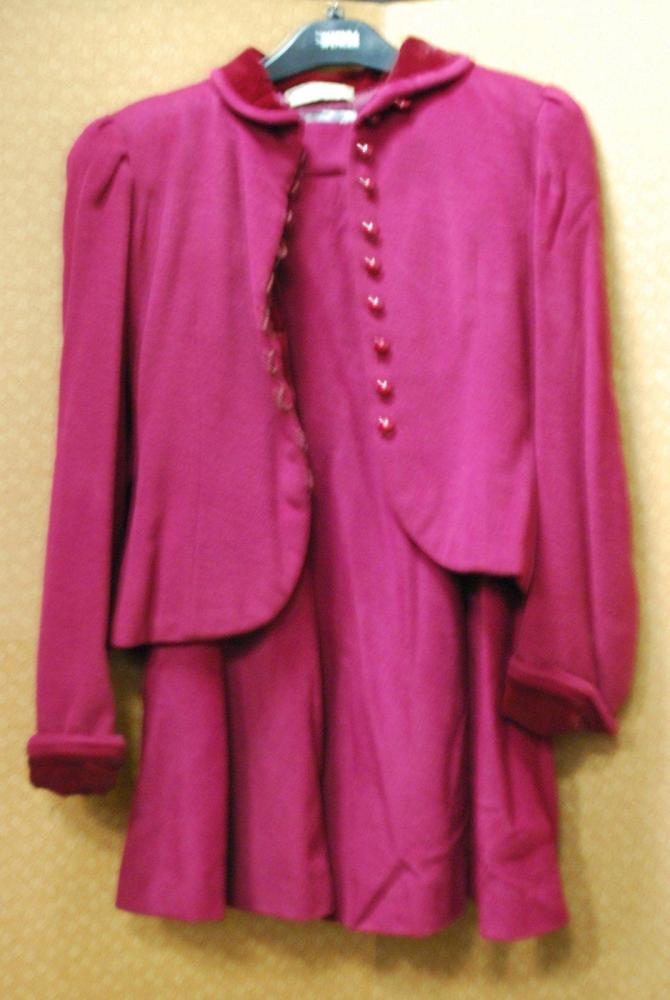 Emanuel UNGARO Couture, n°57.55.35, circa 1978 / 1980

Tailleur en poil de chameau bordeaux, veste cintrée à petit col rond partiellement recouvert de velours, simple boutonnage brides, manches longues à revers; jupe large à lès. (manque la ceinture). Griffes blanches, graphisme noir