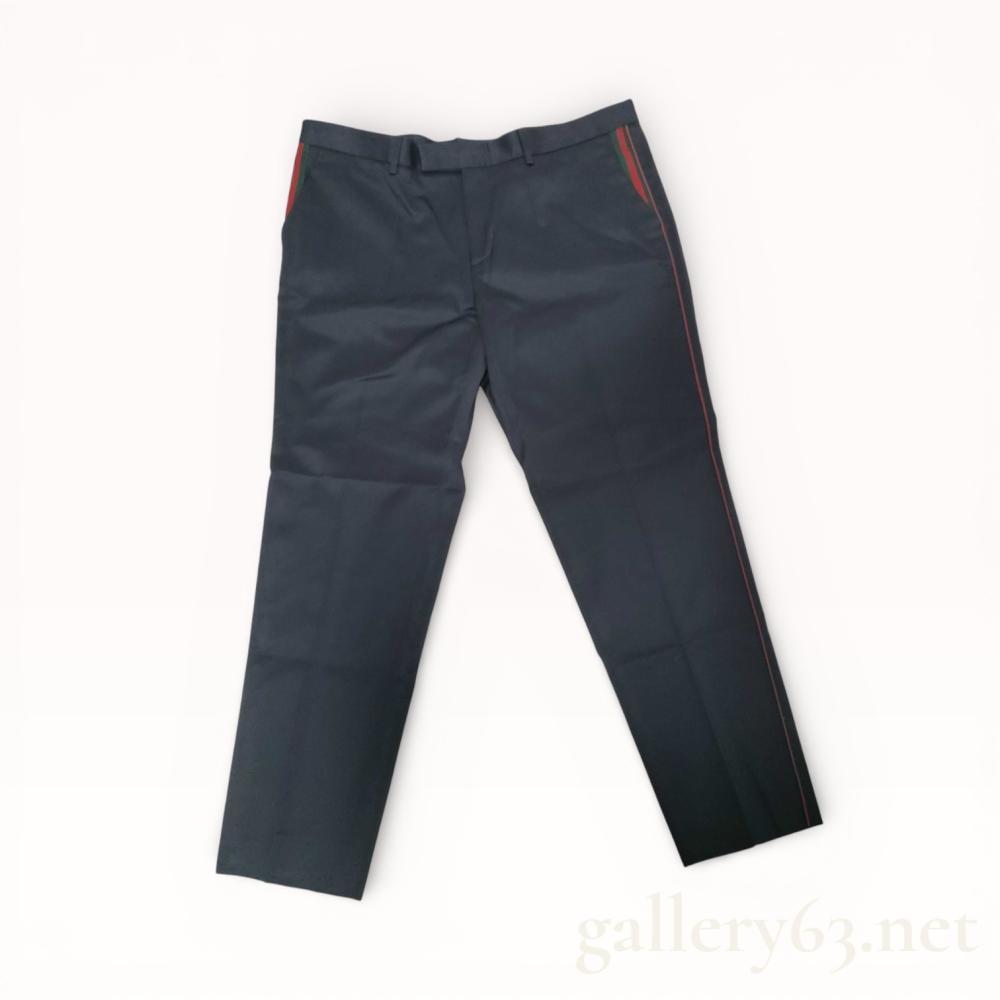 Description
Gucci men’s flat-front dress trousers in dark navy blue cotton, Made in Italy. The design features signature green and red web stripe detailing along the side seams and front pockets, finished with branded hardware and a zip fly closure. Interior labels include the rectangular Gucci tag with red corner stitching and a care label indicating 100 percent cotton composition.
Size IT 56 (180/94A), approximately US size 40 waist.