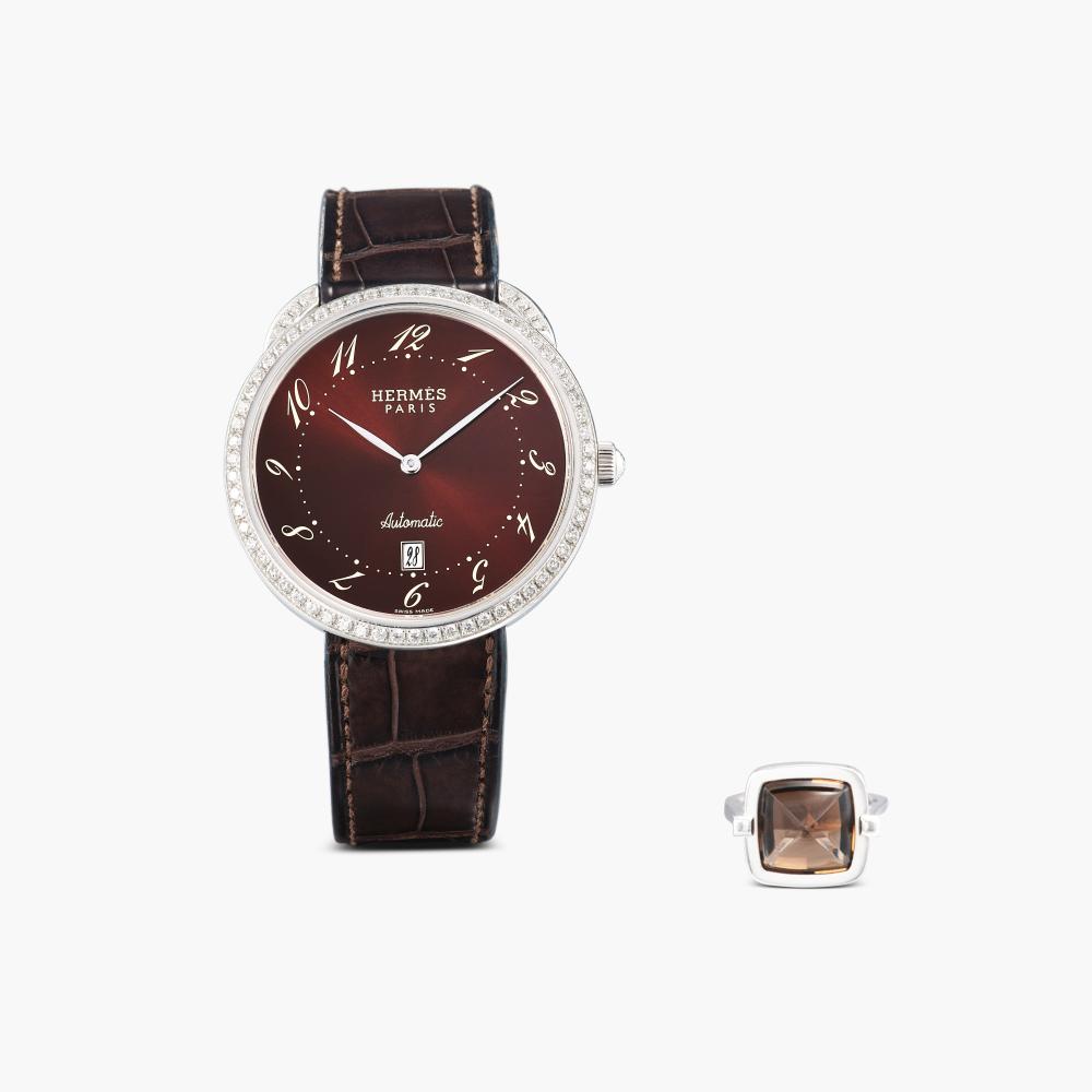 Hermès

Comprising: wristwatch with circular dial decorated with brilliant-cut diamonds, completed by a leather strap and deployant clasp; and ring set with a sugarloaf cabochon smoky quartz.