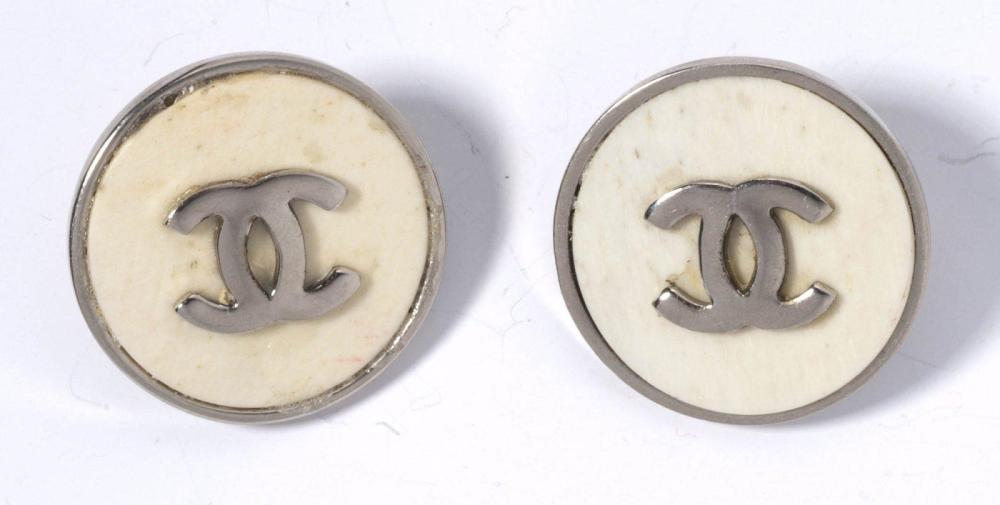 CHANEL

Paire de boucles d’oreilles en métal chromé orné d’une plaque en composite à l’imitation ivoire rehaussé du sigle. Signée
