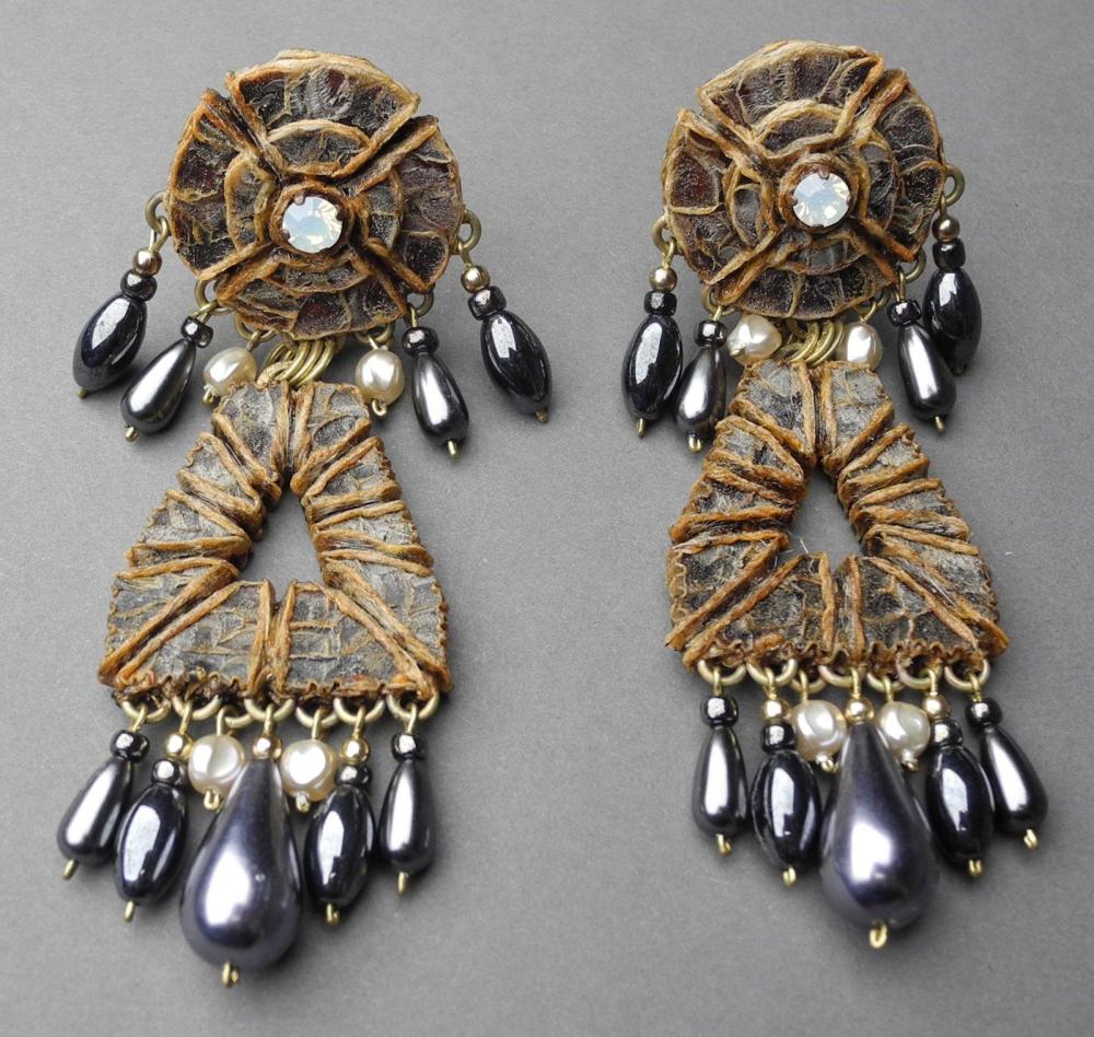HENRY - circa 1960

Paire de pendants d’oreilles clips en résine gravée, rehaussée d’un strass opalin et se finissant par des pendeloques de perles gouttes argentées et de perles baroques Signée