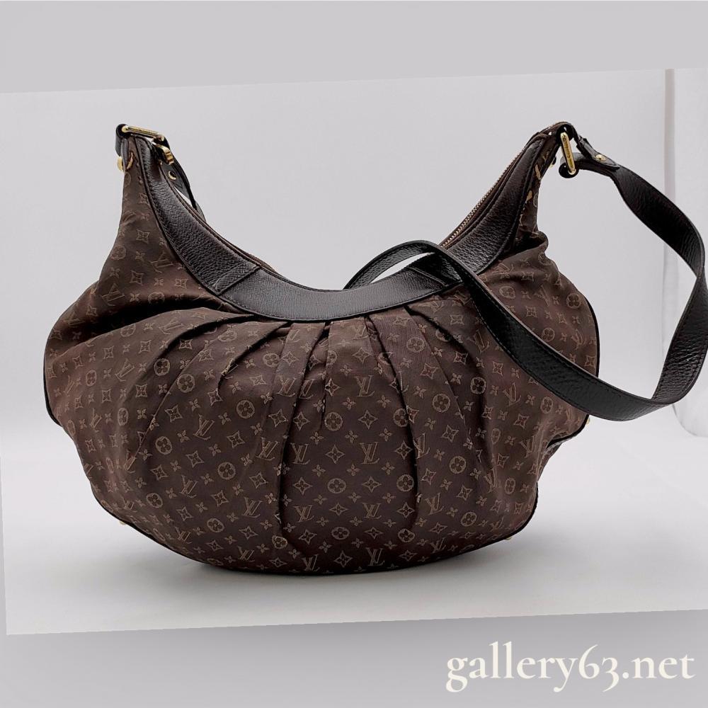 Description
Louis Vuitton Rhapsody MM shoulder bag in Ebene Monogram Idylle canvas, also known as Monogram Mini Lin. The crescent-shaped hobo design features pleated fabric panels, dark brown textured leather trim, and an adjustable flat leather shoulder strap. Gold-tone hardware includes branded buckles, studs, and a top zipper closure opening to a brown textile-lined interior with two slip pockets. An interior leather patch is heat-stamped with the manufacturer mark (R) LOUIS VUITTON PARIS made in France.
Approximately 16 inches W x 11 inches H x 4 inches D.