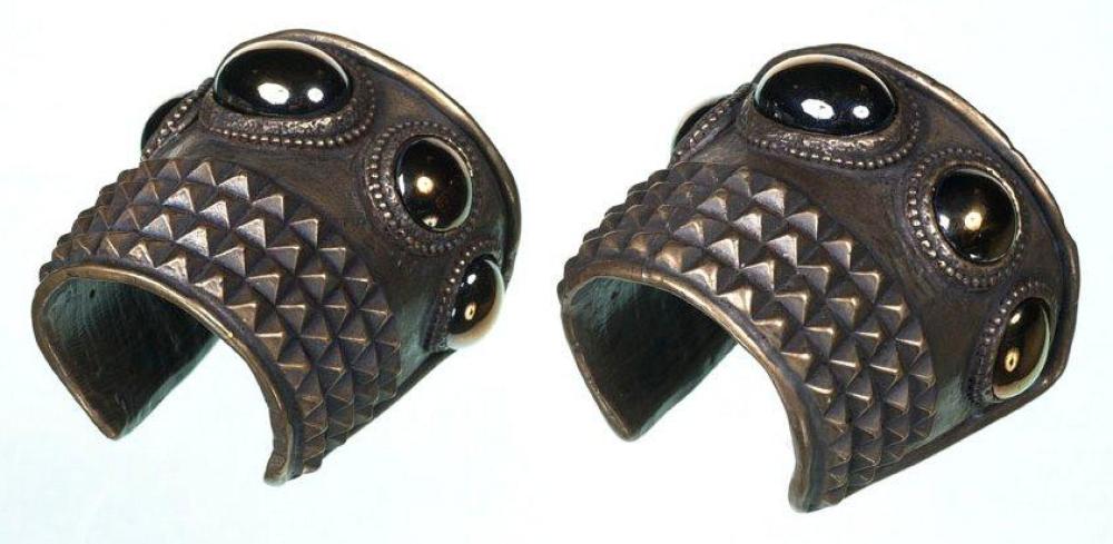 JEAN PAUL GAULTIER CIRCA 1990

Bracelet manchette d’inspiration ethnique en laiton façon bronze à patine brune, gravé d’un motif pointes de diamants sur quatre rangs et rehaussé de cabochons en pâte de verre mordorée. Signé