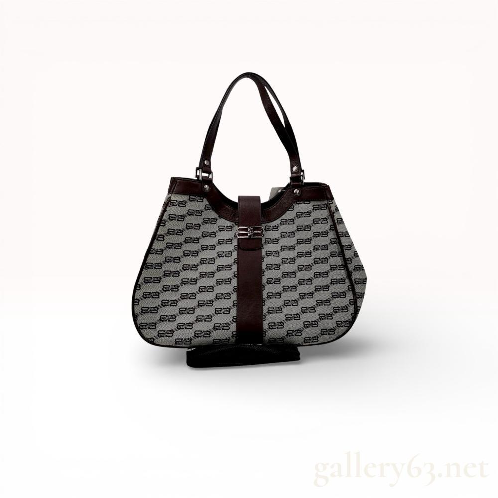Description
Balenciaga BB monogram shoulder bag, late 20th to early 21st century. Features a beige woven canvas body with dark brown leather trim, a curved top, and a central magnetic strap closure with a silver-tone BB logo. The interior is lined with logo-patterned fabric and includes an embossed leather brand patch, while the base is fitted with protective metal feet. Hardware rivets are stamped with Balenciaga Paris.
Width: 14.5 inches
Height: 9.5 inches.