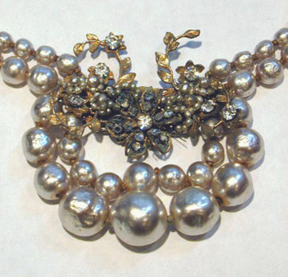 Miriam Haskell Pearl Cluster Choker Necklace 1940s

Lot 246
Miriam Haskell Pearl Cluster Choker Necklace 1940s
 1940s 
 Two strands of baroque graduated pearls with matrix cluster atop a double-strand pearl swag, unmarked.