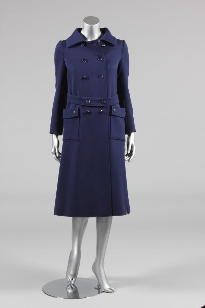 

A Courreges navy wool coat, circa 1970, labelled Couture Future, numbered 0023108a, double-breasted with contrasting decorative white-edged buttons, chest 92cm, 36in
