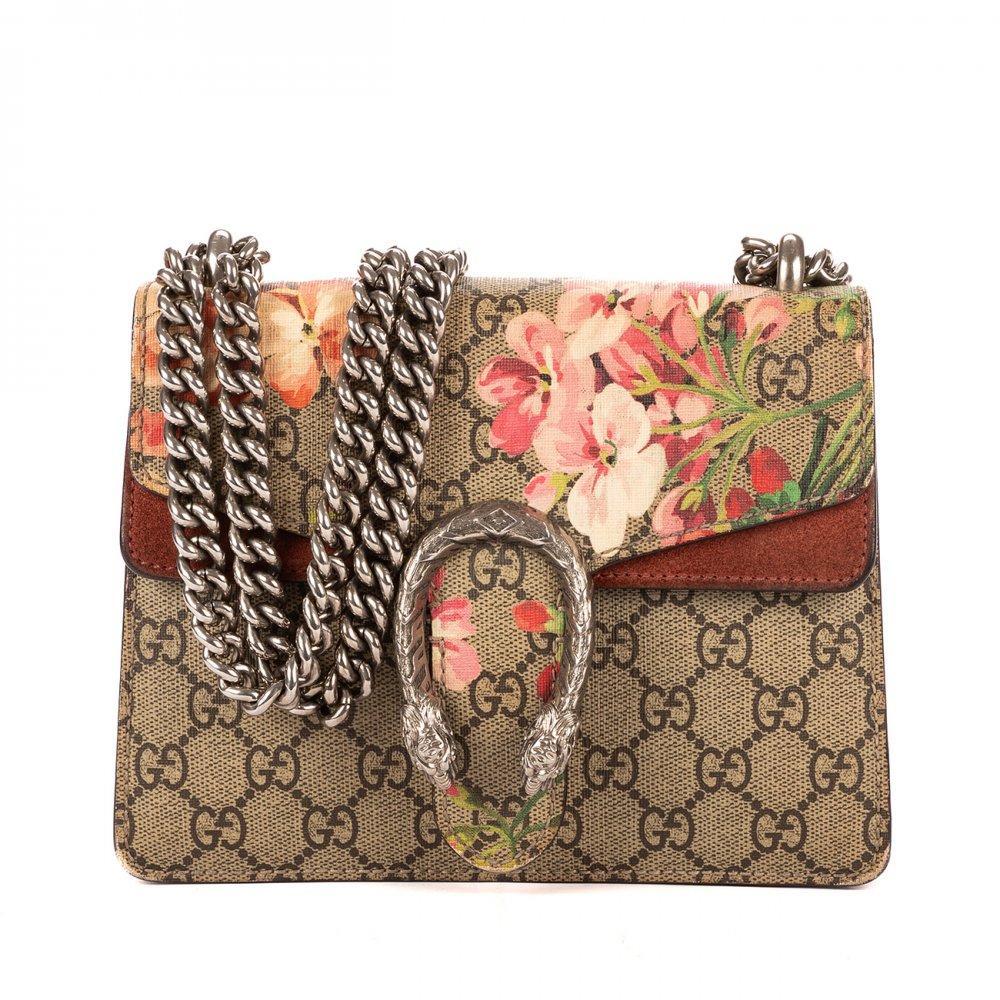 Description

GUCCI
Blooms Dionysus Mini bag.
In monogram fabric in brown tones with painted flowers. Details in burgundy suede. Front flap with iconic jeweled closure in the shape of tiger heads in antiqued finish metal. Long chain that can be doubled to carry over the shoulder. Spacious red suede interior.
Includes dust bag.
With interior numbering.
Very good condition, with normal signs of use.
Measurements: 20 x 15,5 x 5 cm.

The Dionysus Blooms is one of the most successful and popular reinterpretations of the GUCCI house under the creative direction of Alessandro Michele, who has revitalized the brand’s codes by fusing vintage with contemporary. The floral motif, inspired by nature and romanticism, contrasts elegantly with the structured design and the metal clasp in the shape of a tiger’s head, a symbol of strength and sophistication. The silver hardware gives it a modern and versatile touch, suitable for a variety of occasions, from everyday to special events.

Includes dust bag. With interior numbering. Very good condition, with normal signs of use.