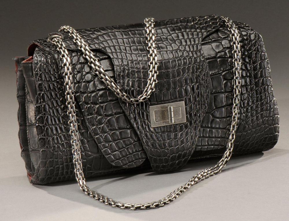 CHANEL

Collection 2010 Rare sac en crocodile pleine peau noire Intérieur en daim bordeaux Anse bandoulière en métal argenté Rabat fermé par un fernoir siglé L: 31 cm; H: 19 cm EN TRES BON ETAT Rarissime: modèle défilé de la collection 2010 Avec son dustbag et dans sa boîte aux 2 camélias