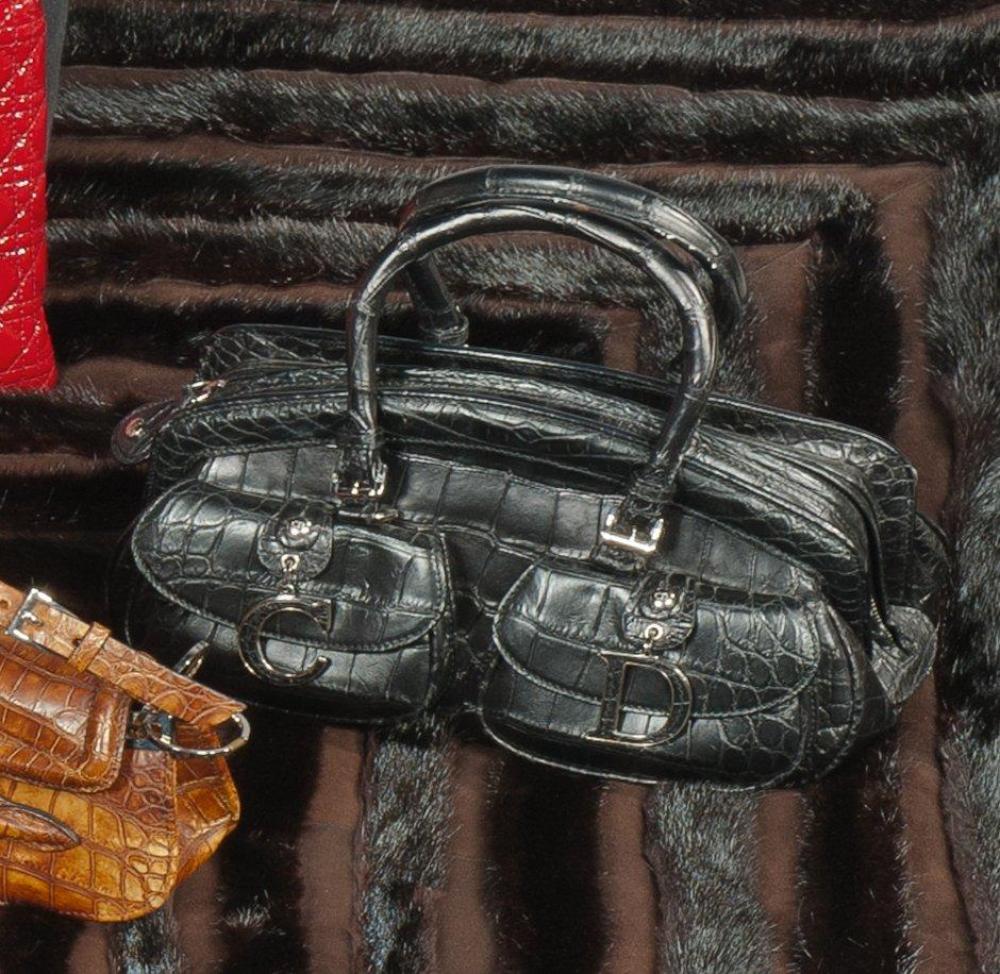 Christian DIOR par John GALLIANO

Sac en cuir noir façon crocodile fermeture éclair, deux petites poches sous rabat ornée chacune d’une lettre émaillée noire, double poignée