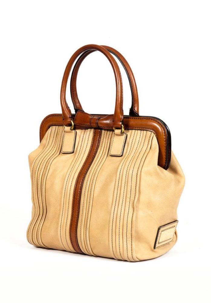 VALENTINO

Sac 28cm en veau beige et marron, fermeture pression aimantée sur armature rigide, rehaussée d’un noeud, double poignée. Bon état