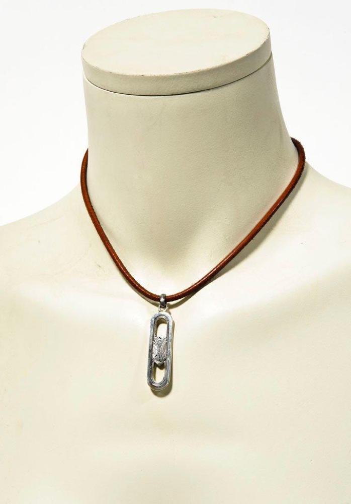 HERMES Paris

Collection touareg Tour de cou en cuir naturel retenant un pendentif ciselé en argent. Pds brut: 18,2 grs environ