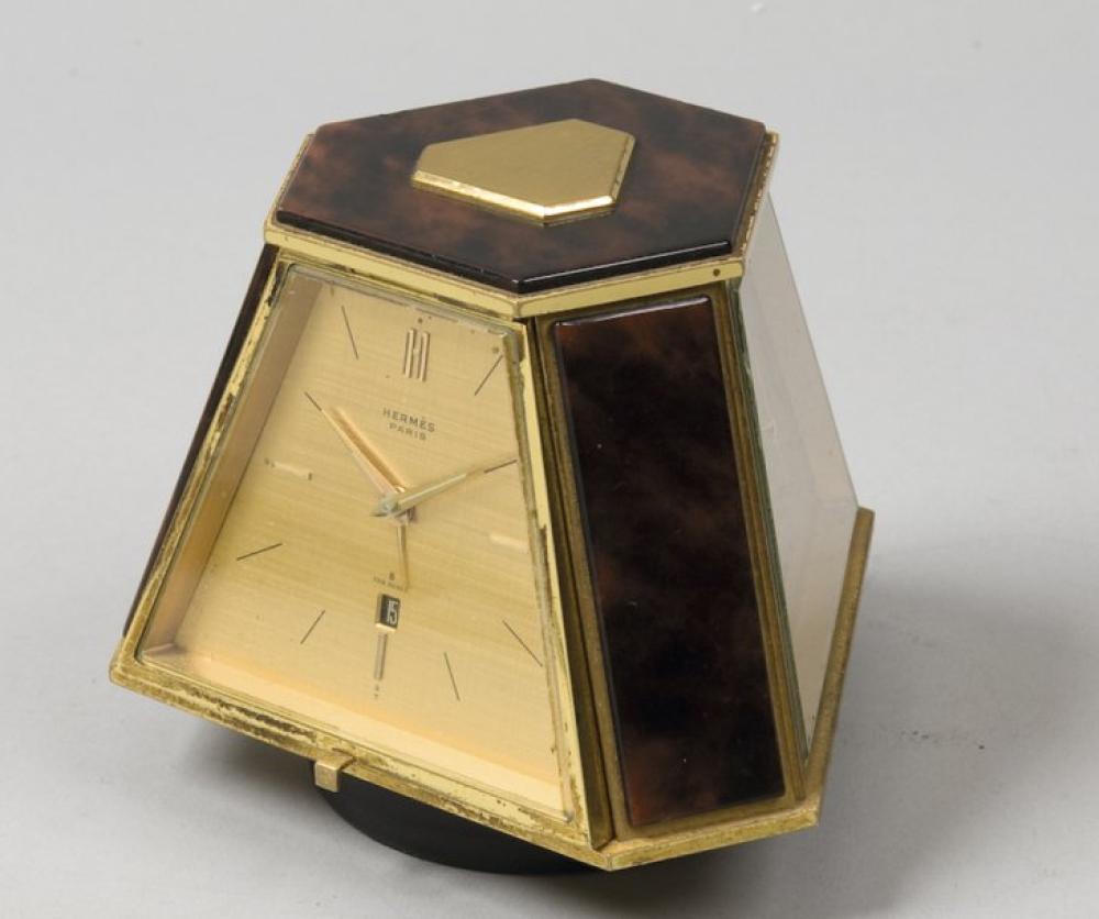 HERMES Paris

*Pendule pivotante à pans coupés sur socle en cuir noir sur lamelles de cuir, bronze doré et laque façon écaille, comprenant un réveil mouvement mécanique index à 6 H, un baromètre, un thermomètre.