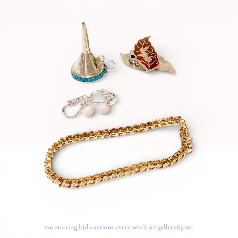 Description
Assortment of sterling silver and costume jewelry accessories including a perfume funnel, brooch, earrings, and bracelet. Features a Mexican .925 sterling silver funnel with turquoise chip inlay, an orange-red guilloche enamel leaf brooch, a pair of silver-toned clip-on earrings with pink beads, and a gold-plated sterling silver tennis bracelet set with clear faceted stones. Funnel is stamped MEXICO 925 TTP, and the bracelet is marked 925 CHINA.
Funnel height: 3.5 cm
Brooch width: 4 cm
Bracelet length: 18 cm.