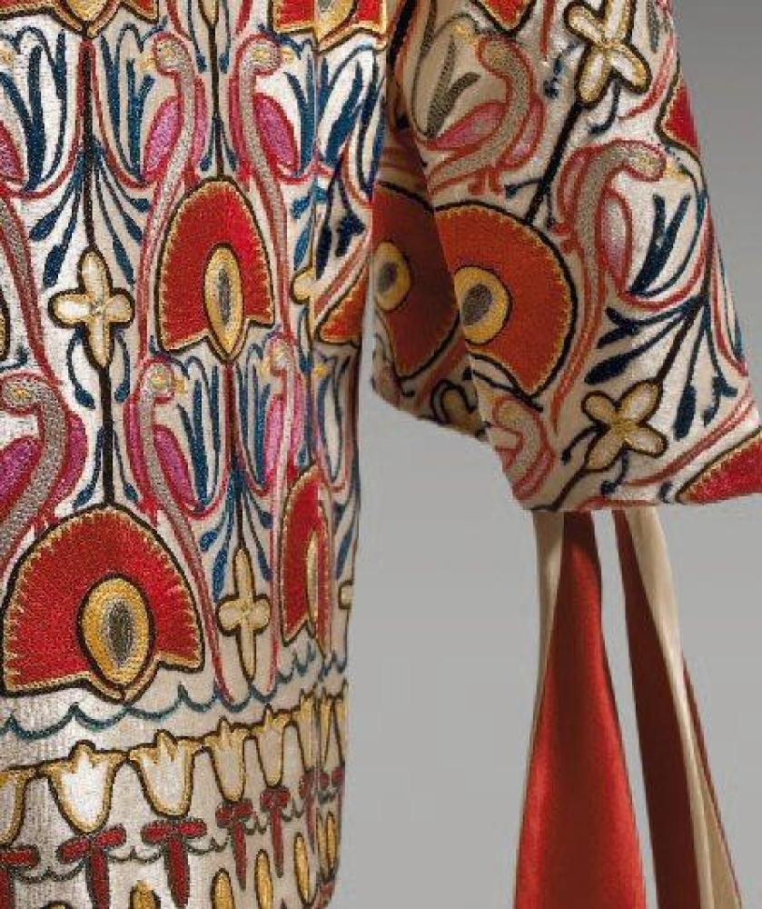 Jeanne LANVIN

Paletot en soie satinée écrue rebrodée aux points de Beauvais d’un motif végétale Art Déco, encolure remontante, parementure sans boutonnage, manches 3/4 ornée de rubans double face écrue, bordeaux pour être noués. Griffe blanche, graphisme noir, rouge précédé du sigle.