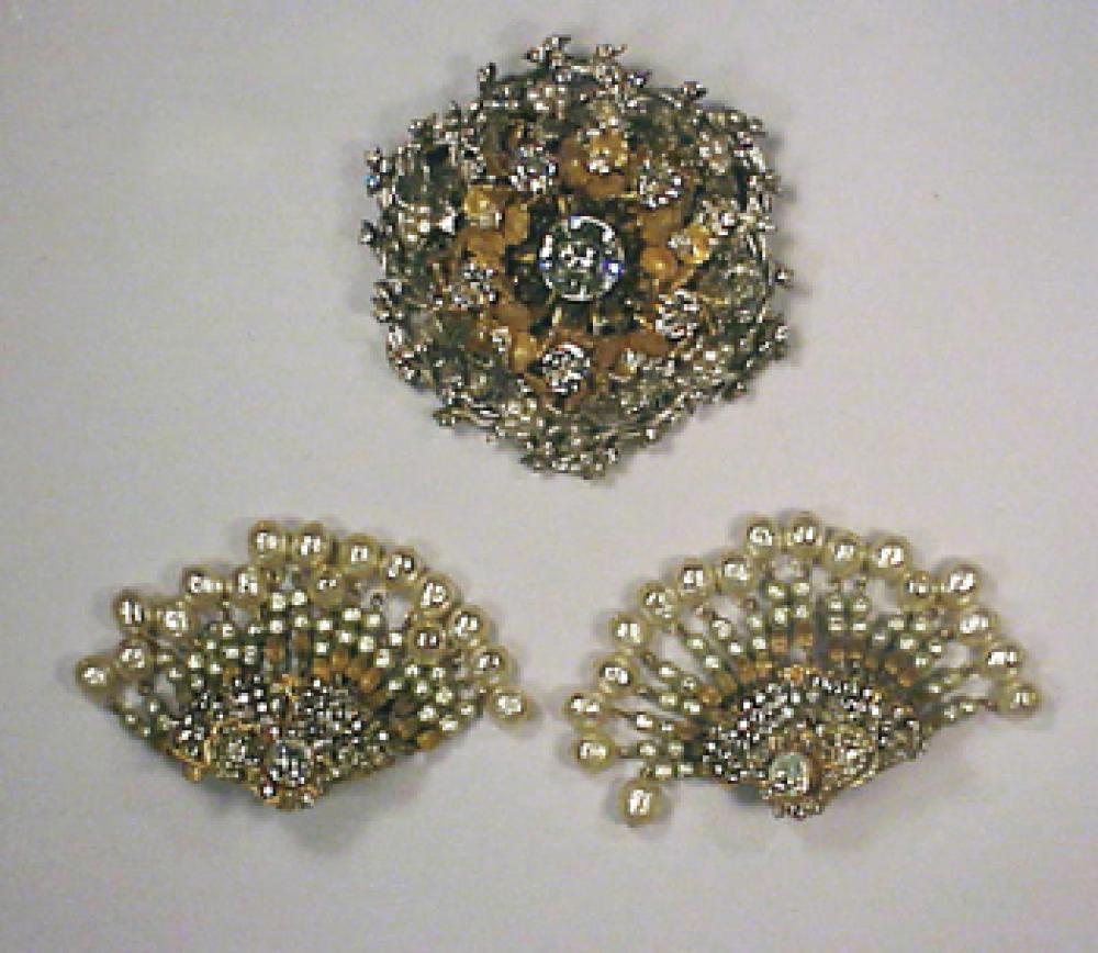Miriam Haskell Brooch and Earrings

Lot 222
Miriam Haskell Brooch and Earrings
 The brooch round, set in silver metal, clusters of gilt-metal flowers and silver metal leaves and pearls, rhinestone center, the earrings with rhinestone mounts and multiple pearl strand pendants, each marked..
