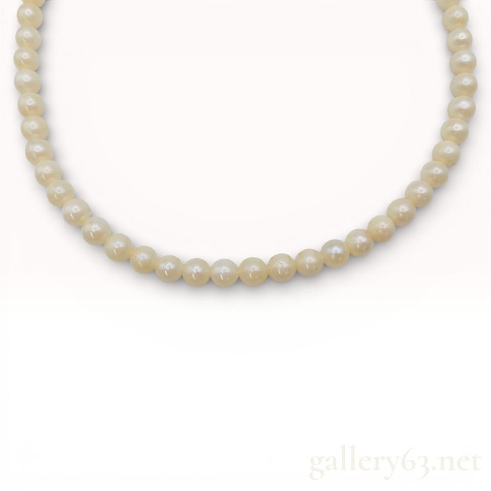 Description
Single strand of graduated freshwater cultured pearls, mid to late 20th century. The pearls feature a cream body color with soft luster and are individually knotted on a white cord. The necklace is secured with an oval silver filigree fishhook box clasp bearing the stamped mark SILVER.
Length: Approximately 16 inches
Pearl size: Approximately 6mm - 7mm.