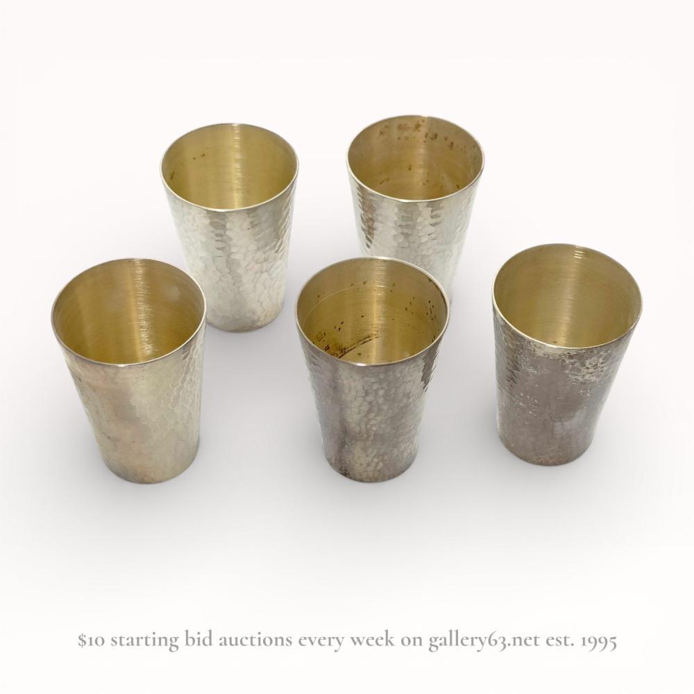Description
A set of Japanese silver sake cups (ochoko) retailed by the Mitsukoshi department store, likely Meiji or Taisho period. Each vessel features a tapered form with a hand-hammered martele exterior and a gold-washed vermeil interior. The bases are incised with the characters éè£½ (Ginsei), indicating high-purity silver, and ä¸è¶ (Mitsukoshi).