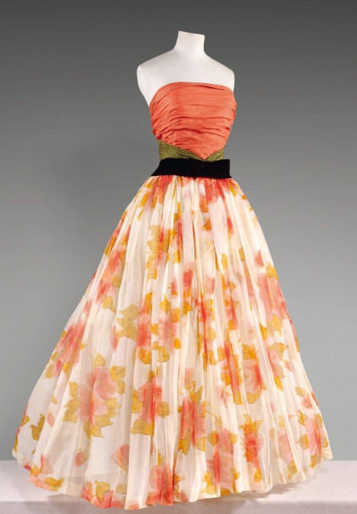 Pierre BALMAIN

Robe du soir, haut bustier en gazar corail drapé souligné de gazar vert, jupe très ample en organza ivoire imprimée d’importante fleurs corail et beige, taille soulignée d’une ceinture incurvée de velours noir. Griffe blanche, graphisme noir