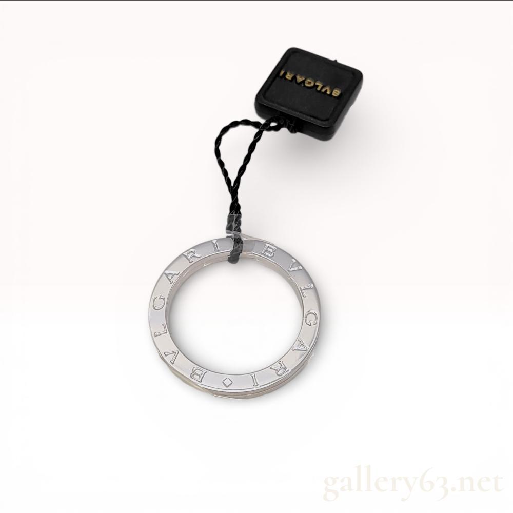 Description
Bvlgari B.zero1 key ring in sterling silver, contemporary. The flat band features the BVLGARI logo engraved twice around the face, separated by diamond-shaped symbols. This item is accompanied by its original branded packaging, including a brown textured presentation box, a cream-colored snap-button pouch, and a shopping bag.
Inner diameter: 21 mm (US ring size 11)
Outer diameter: 30 mm.