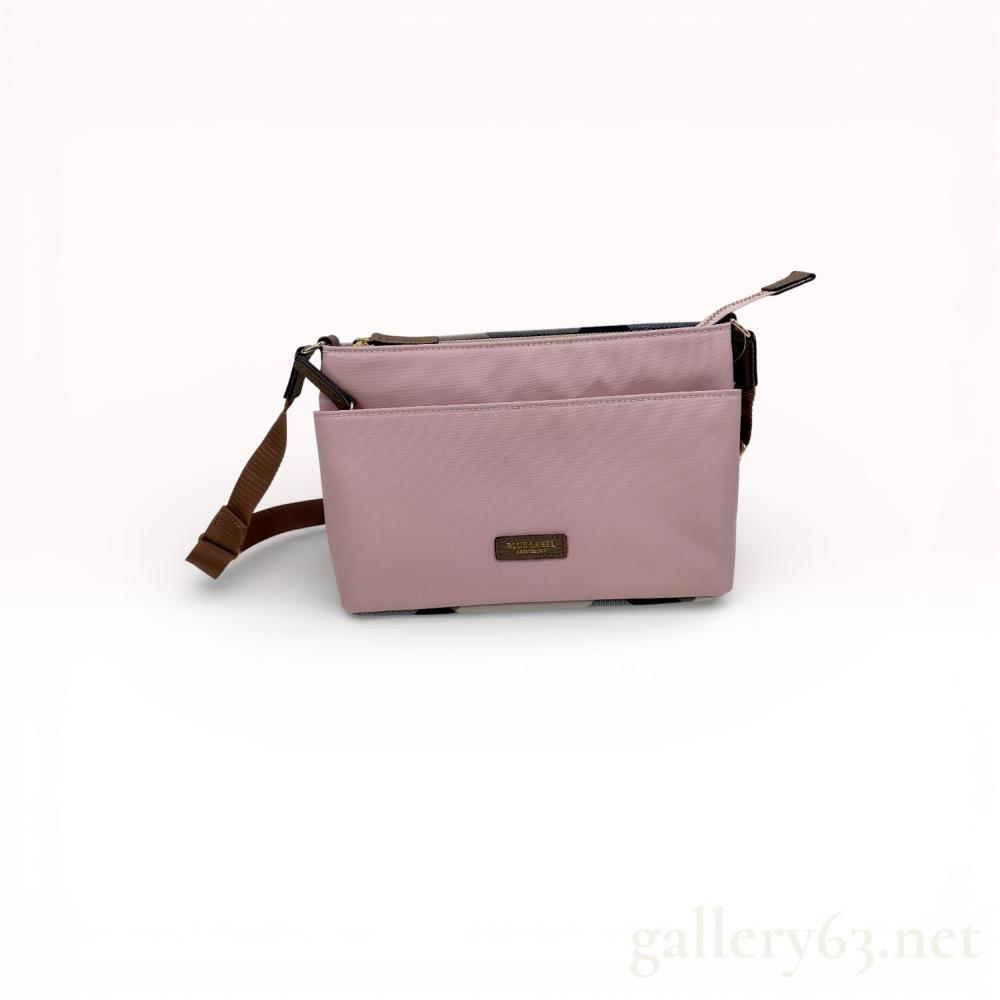 Description
Blue Label Crestbridge nylon crossbody bag featuring a pink synthetic body and brown grained leather trim. The design includes a front slip pocket, a signature check pattern fabric base, and an adjustable brown webbing strap with gold-tone hardware. The front is adorned with an embossed leather brand patch, and the interior is lined with brown fabric containing a blue brand label.
Approximately 10 inches width.