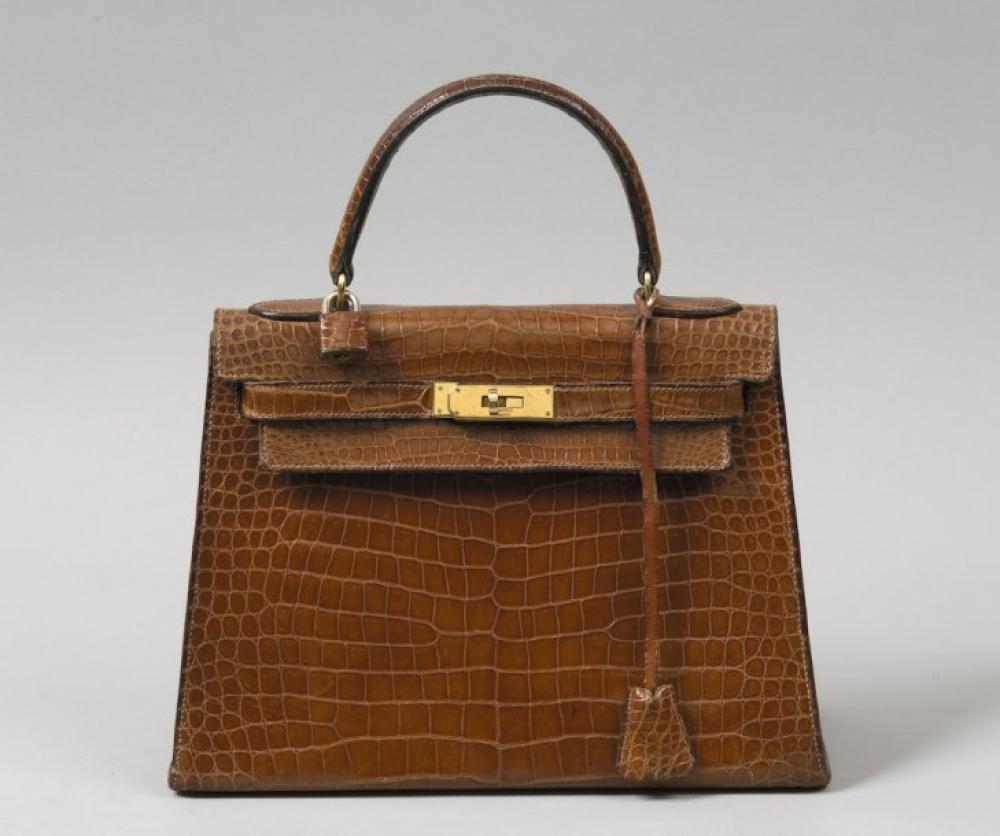 HERMES Paris

*Sac «Kelly» 29 cm en crocodile havane, attaches et fermoir plaqué or, poignée, clés, cadenas.