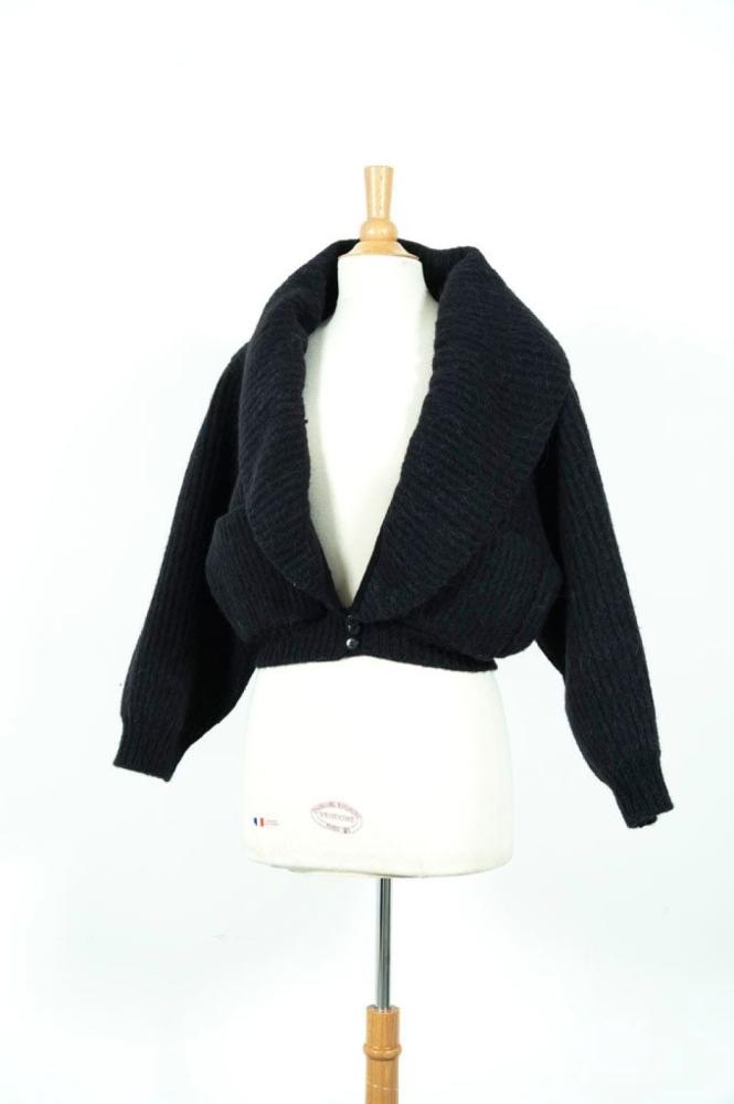 ALAIA

Veste courte en laine mohair noir, col châle sur profond décolleté, effet de basques boutonnés manches longues gigotsimple boutonnage à trois boutons, deux poches plaqués à bord arrondis. Taille S environ