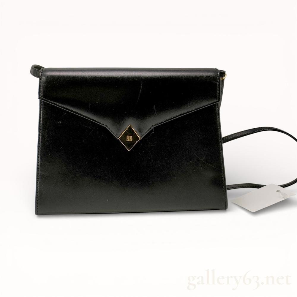 Description
Vintage Givenchy Sacs envelope shoulder bag, late 20th century. Constructed from smooth black leather with a ribbed textile lining, featuring a gold-tone diamond-shaped 4G logo emblem and a thin adjustable leather strap. The interior contains a zippered pocket with a YKK pull, and the bag secures with a magnetic snap closure marked TOWANNY.
Width: 9.5 inches
Height: 7.5 inches
Depth: 2.5 inches.