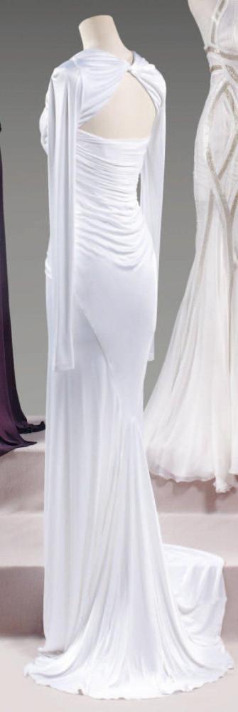 VERSACE par Donatella VERSACE, circa 2000

Robe du soir longue en jersey rayonne blanc, haut bustier drapé jusqu’aux petites hanches, effet de caraco à manches longues, jupe fluide, longueur à traine. Griffe noire, graphisme beige