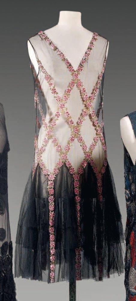 Anonyme

Robe en tulle noir brodé de paillettes, de perles roses à motif de fleurettes se rejoignant par un feuillage de paillettes or et formant des losanges tombant sur les quillesà partir des hanches d’une jupe à volant ,décolleté en pointe, sans manches (petit trou)