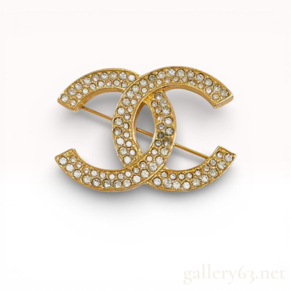 Description
Chanel interlocking CC logo brooch, circa late 1970s to early 1980s. The gold-plated base metal features a textured bark-like finish on the sides and reverse, with the front pave-set with clear round rhinestones. The reverse bears an oval cartouche marked with a copyright symbol, CHANEL, and the production number 174.
Width: 1.65 inches
Height: 1.25 inches.