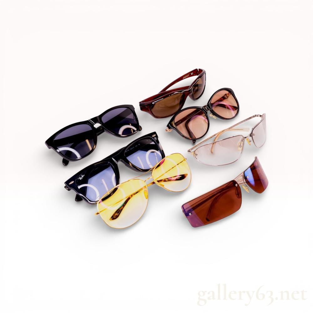 Description
A collection of seven pairs of designer and sport sunglasses from makers including Ray-Ban, Oakley, Celine, Prada, Zeal Optics, and Hydro-X. Featured models include Ray-Ban Wayfarer RB2140-F in black acetate with light blue lenses and Celine CD5178SZ tortoiseshell cat-eye frames. The assortment also contains Prada SPR 56D semi-rimless frames, gold-tone Hydro-X aviators with yellow lenses, and Zeal Optics wraparound sport glasses. Marks include brand logos and model numbers such as SPR 56D and CD5178SZ on interior temples.