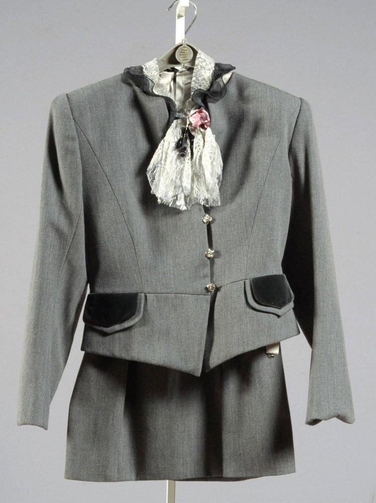 Emanuel UNGARO

Couture n]8257.6.10.88 Autome Hiver 1988 Tailleur en lainage gris ousris, veste à pretites basques à encolure ronde sur petite échancrure, simple boutonnage bijou, deux fausses poches à rabat, manches longues, jupe droite empiècement de velours. Se porte avec une blouse en soie grise à effet drapé, boutonnage dos, encolure rehaussé d’un jabot de dentelle. Griffe blanche, graphisme noir
