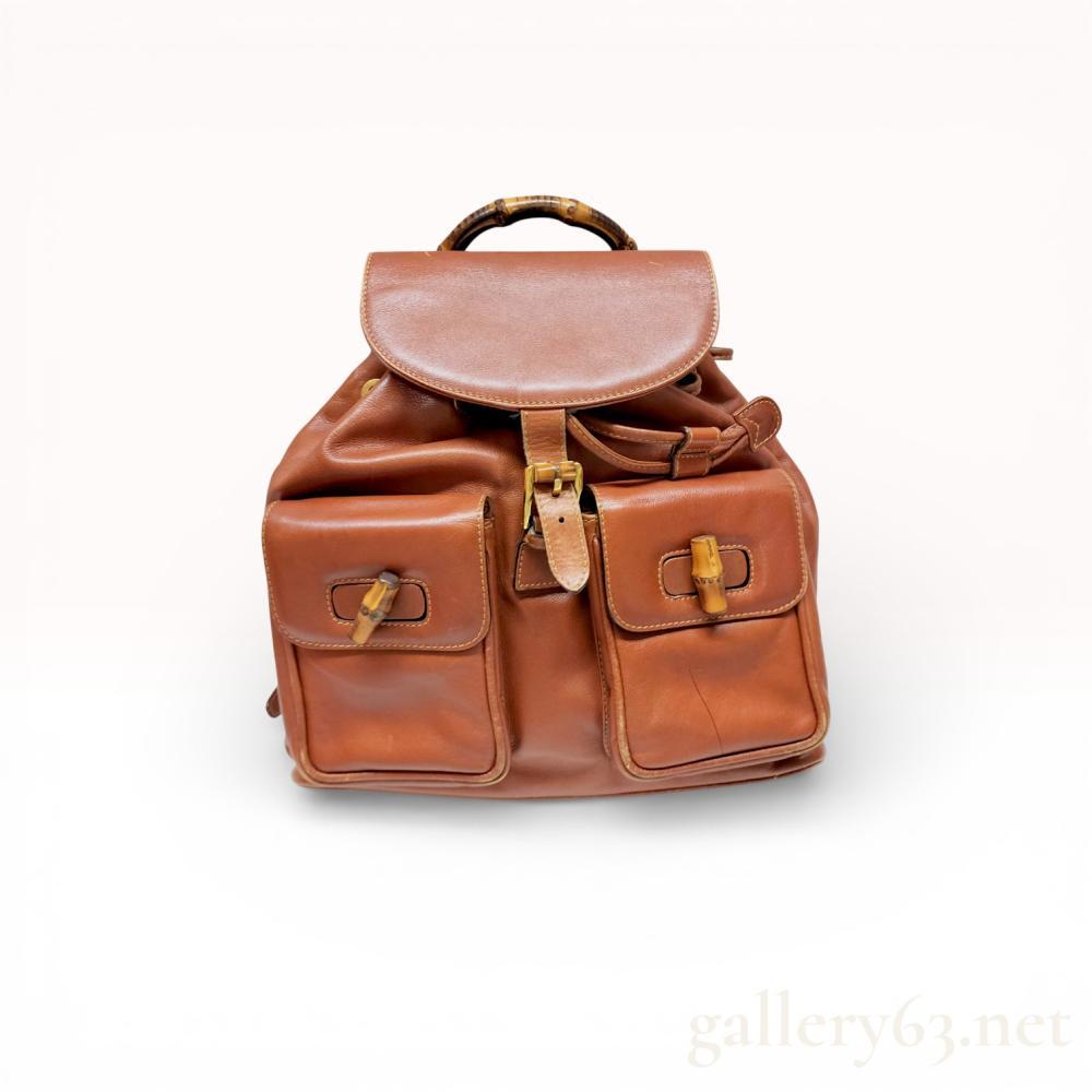 Description
Leather backpack from the Gucci Bamboo collection, featuring a tan leather body with natural bamboo accents. The design includes a fold-over top flap with buckle closure, two exterior front pockets with bamboo toggles, and a curved bamboo top handle. It is equipped with adjustable leather shoulder straps and gold-tone metal hardware.
Base Width: 9.5 - 10 inches.