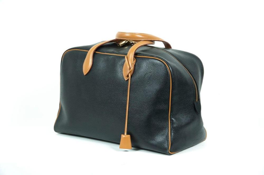 HERMES Paris made in France année 1995

Sac "Victoria" de voyage 44cm en cuir Buffalo noir et cuir gold à surpiqûres blanches, fermeture éclair à double curseur, double poignée, clefs, cadenas. Bon état (légères usures aux coins)