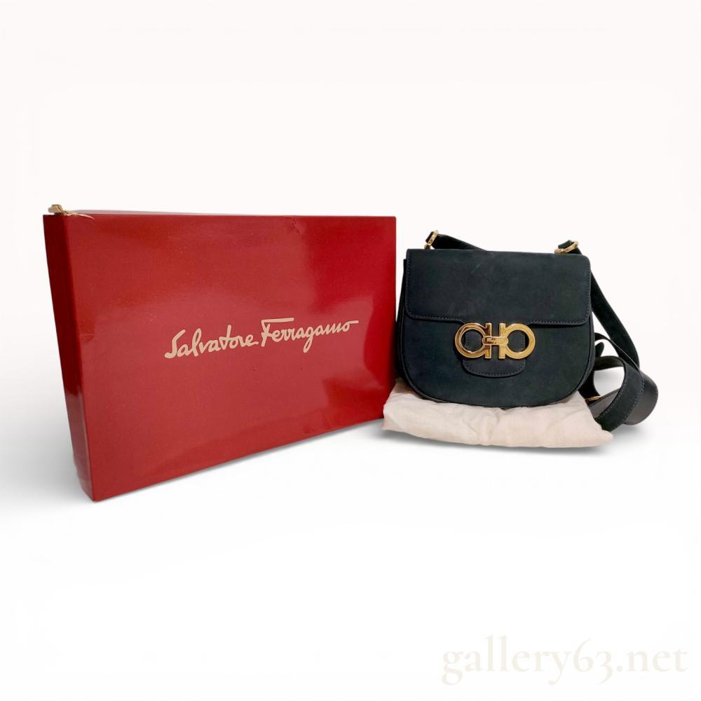 Description
Authentic Salvatore Ferragamo Gancini shoulder bag in black suede, featuring a softly structured silhouette with curved flap. The front is accented by an oversized gold tone Gancini logo clasp. The design includes an adjustable shoulder strap with gold tone hardware and flap closure. Includes box and dust bag.