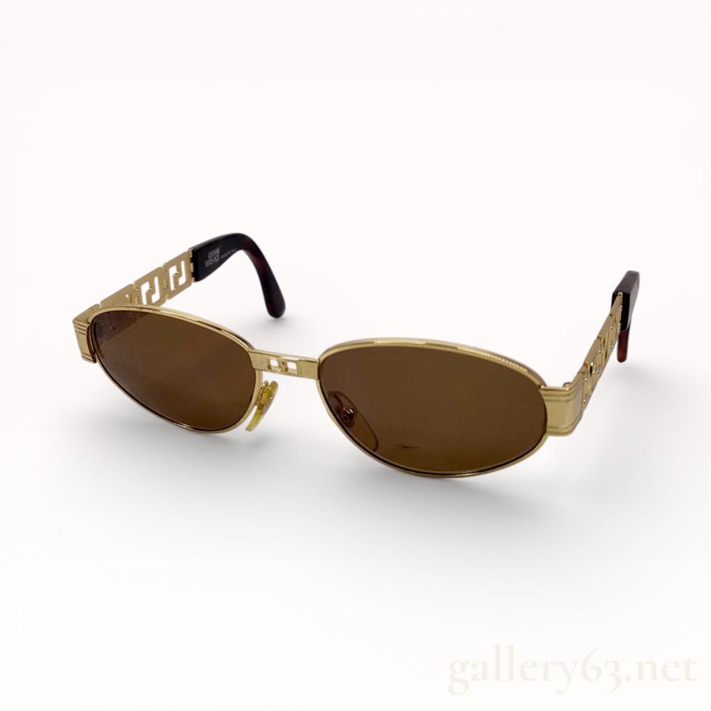 Description
Gianni Versace oval-frame sunglasses, model MOD.S44 COL.030, made in Italy. The gold-tone metal frames feature a rectangular bridge and open-work Greek key temples accented with Medusa head medallions and tortoiseshell-patterned acetate tips. Interior temples are marked GIANNI VERSACE MADE IN ITALY and MOD.S44 COL.030. Includes an original black soft-sided case with an embossed Medusa logo.