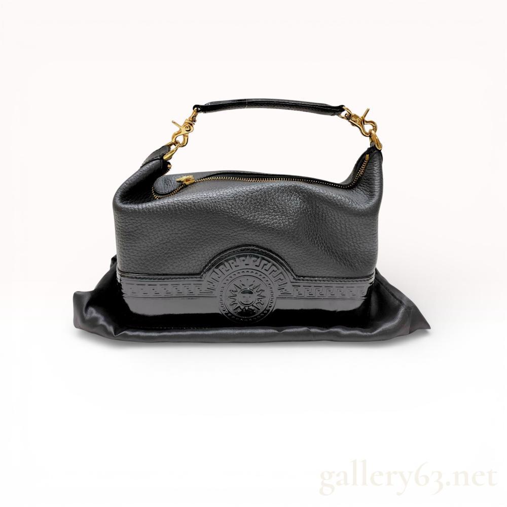 Description
Gianni Versace vintage vanity bag, circa 1990s. The piece is constructed with a pebbled leather body and a structured patent leather base featuring an embossed Greek key and sunburst motif. It includes gold-tone hardware with a sunburst zipper pull, a detachable patent leather handle, and a logo-jacquard interior with a gold-stamped leather brand label.
Length: 8.5 inches
Depth: 3.5 inches
Height: 5.5 inches.