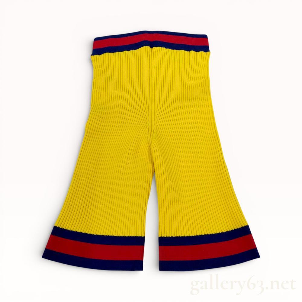 Description
Gucci contemporary high-waisted flared shorts in a vertical ribbed knit construction. The garment features a vibrant yellow body accented by navy blue and red striped trim at the elasticized waistband and leg openings. Fabricated from a blend of 69 percent viscose and 31 percent polyester, the interior retains original brand, size S, and care labels.
Length: Approximately 18 inches.