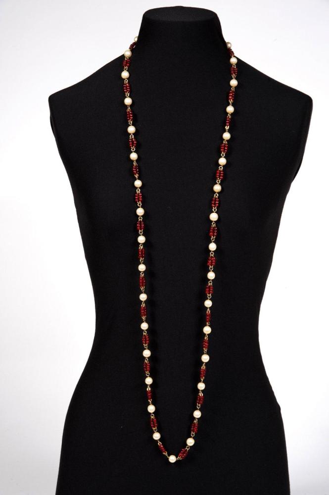 CHANEL (ATTRIBUÉ À)

Sautoir composé de perles blanches entrecoupées de perles de verre de couleur rubis
