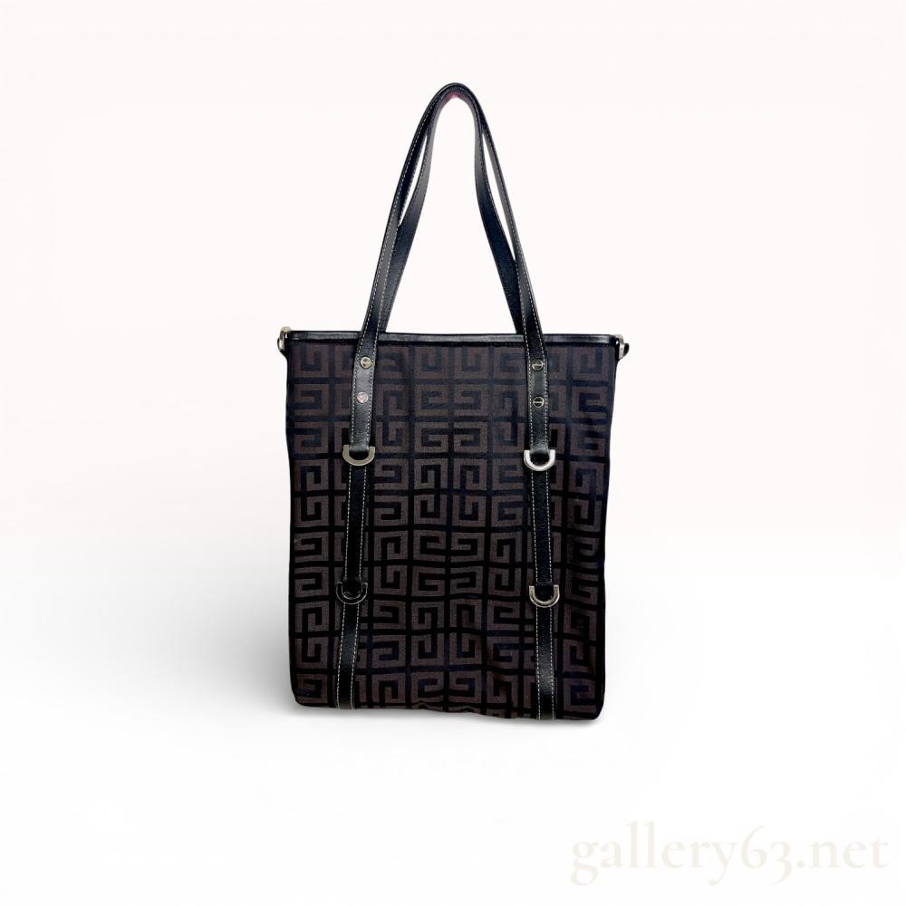 Description
Fiorelli Brooke tote bag featuring a black and bronze-toned geometric jacquard canvas exterior, contemporary. The bag is constructed with black trim, dual flat shoulder straps with contrast white stitching, and silver-tone hardware including branded rivets. The interior is finished with a branded logo-print lining and includes one zippered pocket and two slip pockets; no serial or date codes are visible.