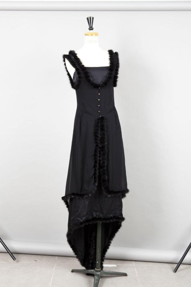 CHANEL Circa 2003

Robe longue à bretelles en soie noir, longueur asymétrique gansé de morceaux de vison se porte avec un gilet à l’identique d’inspiration 1910-1915