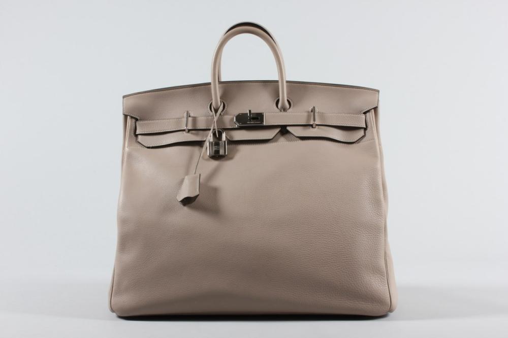 

An Hermès gris tourterelle clemence leather haut courroies overnight bag, 2000, blind stamp D, with silver palladium hardware, key fob and padlock, 50cm, 19 1/2in
