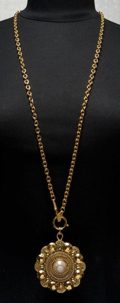 CHANEL

Pendentif en métal doré ciselé et martelé de forme fleur orné au centre d’une demi perle; retenu par une chaîne en métal doré. Signés