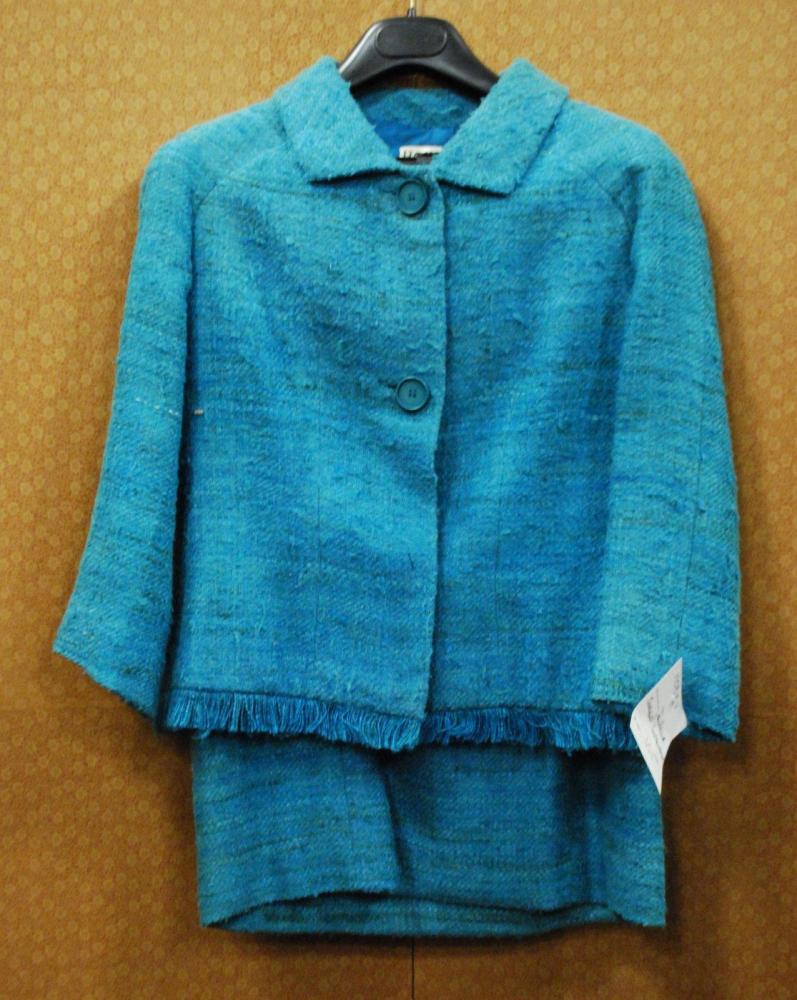 HOBBY Milano, circa 1960

Tailleur en tweed turquoise, veste à petit col, simple boutonnage à deux boutons, bas de la veste à effet effiloché, manches longues, jupe droite. Griffe blanche, graphisme noir