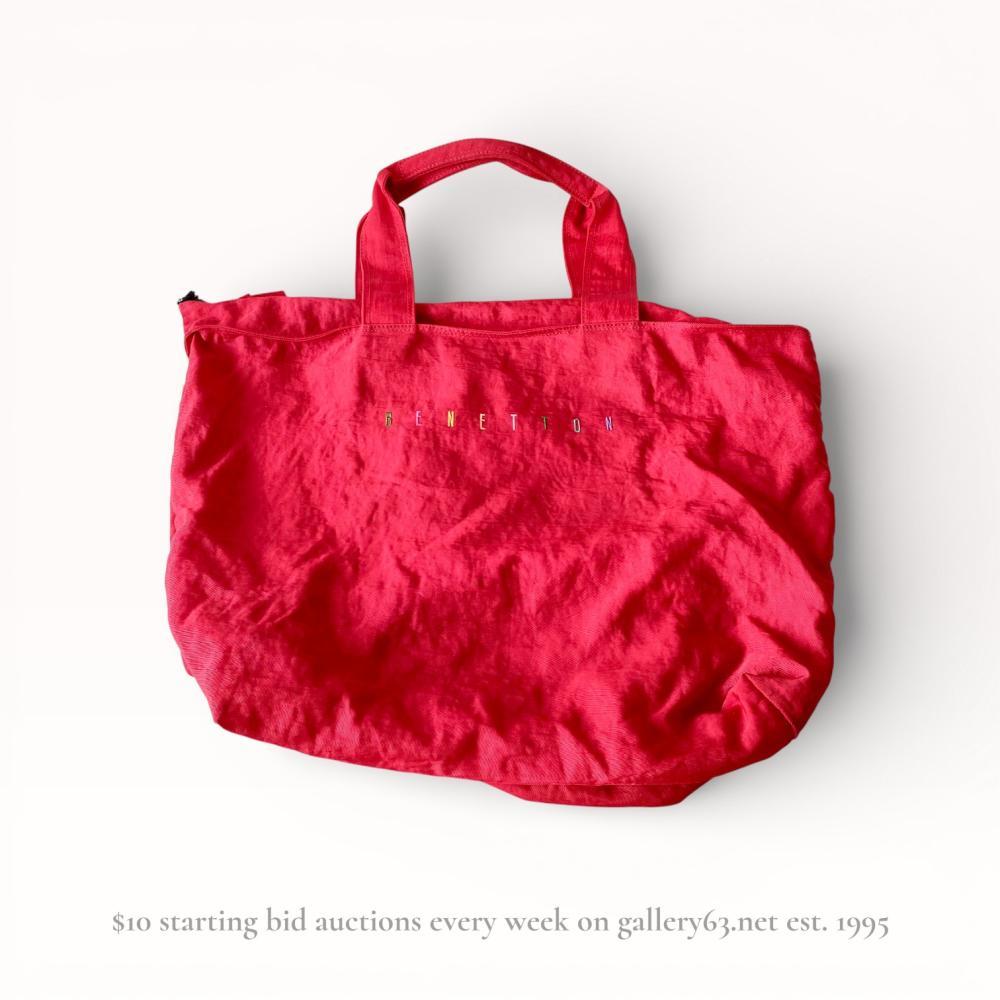 Description
Benetton large nylon tote bag, circa 1990s. Constructed from red synthetic fabric with a diagonal rib-weave texture, featuring a black plastic zipper and twin top handles. The front face displays multi-colored embroidered block lettering, and the interior is finished with black fabric binding.
Width: 18 inches
Height: 13 inches.