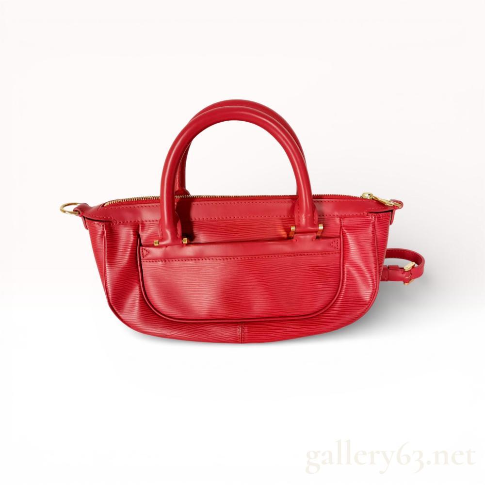 Description
Louis Vuitton Dhanura PM handbag in Castillan Red Epi leather with gold-tone brass hardware. The design features an elongated silhouette with double rolled top handles, a front exterior slip pocket, and a top zip closure. It includes a matching detachable and adjustable leather shoulder strap. An embossed LV logo is present on the front corner, and the zipper pull features branded marks.
Approximately 12.5 inches W x 7 inches H x 4 inches D.
