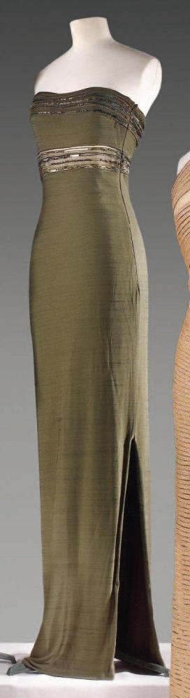 Gianfranco FERRE, circa 1990

Robe fourreau en jersey polyester strié vert, poitrine soulignée de perles, de soutaches et de tulle, rappel au millieu du buste. (fils tirés, manques) Griffe noire, graphisme blanc